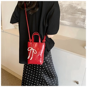 Détail du mini sac rouge avec nœud en perles et poignée nouée pour femmes