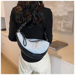 Detail of blue denim and black leather crossbody bag with chunky knotted shoulder strap