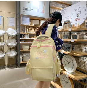 Detail of yellow school backpack with heart embroidery and multi-layer zipper pockets