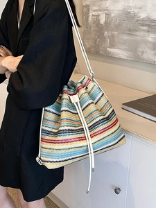 Colorful striped straw bucket backpack with white leather straps and drawstring closure