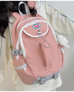 Pink and white nylon backpack featuring multi-layer zip pockets and side buckles