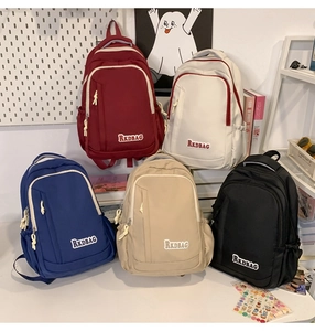 Group shot of casual backpacks in five colors including navy, black, and beige for students