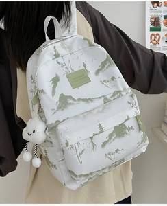 Details des weißen Canvas-Rucksacks mit grüner Landschaft und Wolken-Plüschanhänger
