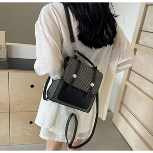 Detail of tweed and black leather backpack featuring silver hardware and adjustable straps