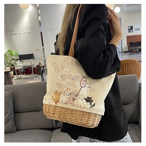 Dettaglio della borsa in tela con gatto e base in rattan naturale intrecciato