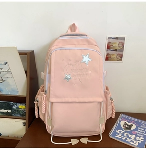 Detailed view of pink school backpack with star embroidery and multiple storage pockets
