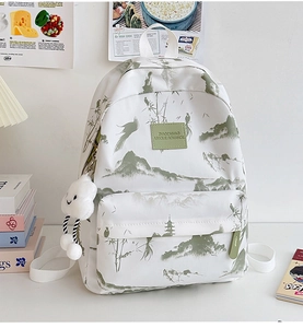 Detail eines weißen Canvas-Rucksacks mit grünem Bambusdruck und Wolken-Plüschanhänger