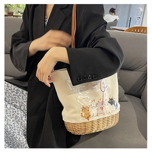 Dettaglio della borsa tote in tela con illustrazione di gatto e base in paglia intrecciata