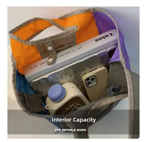Internal capacity of large color-block tote bag holding tablet, magazine, and bottle