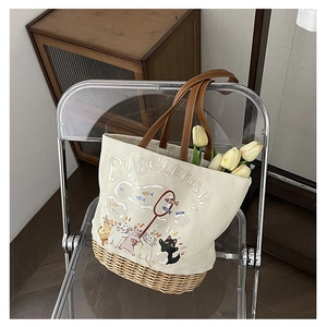 Dettaglio borsa tote in tela con base in paglia intrecciata, stampa gatto e manici