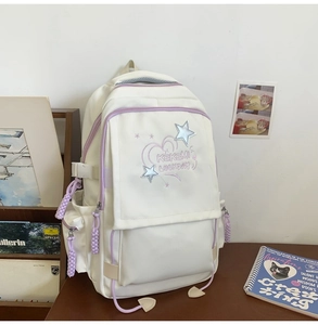 Close-up of white and purple school backpack with star embroidery and side pockets