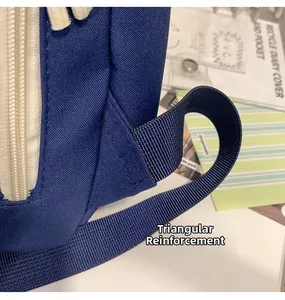 Detail showing durable triangular reinforcement stitching on blue canvas backpack straps
