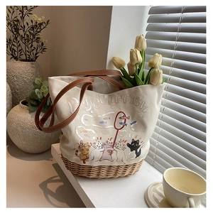 Dettaglio della borsa tote in tela stampata con base in rattan e manici in pelle
