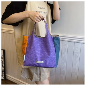 Detail of color-block canvas tote bag featuring purple, orange and blue patchwork design