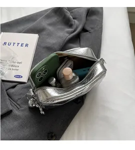 Top view of spacious interior in silver metallic handbag showing daily essentials