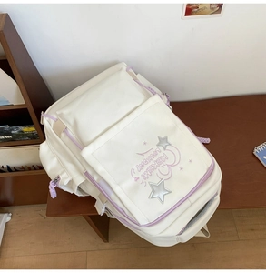 Detail of white school backpack with purple star embroidery and mesh side pocket