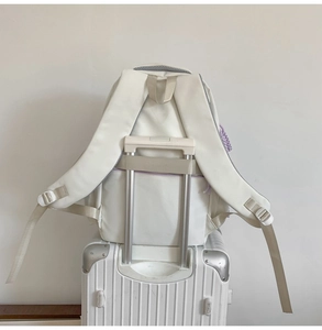 Detailed view of white school backpack with a functional luggage strap for travel convenience