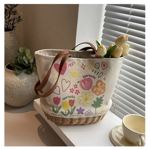 Dettaglio della borsa tote in tela con base in paglia e illustrazioni floreali colorate