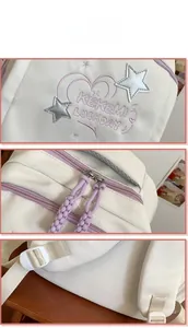 Detail view of white canvas backpack featuring purple heart embroidery and star charm