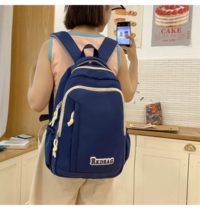 Detail of dark blue school backpack with RKDBAG logo and cream zipper outlines