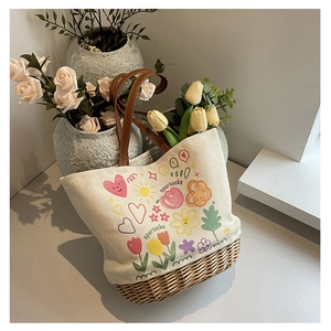 Dettaglio borsa tote in tela con base in paglia intrecciata, graffiti e manici in pelle