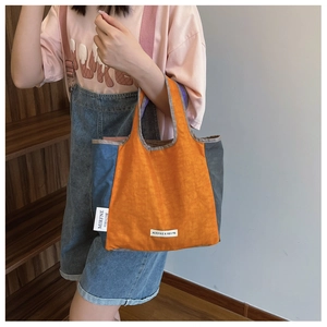 Detail of contrast color tote bag with MIRFNE brand label on waterproof nylon fabric