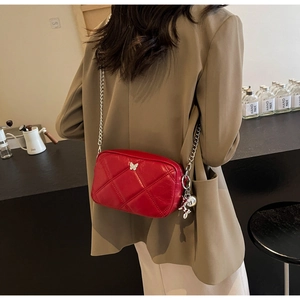Red quilted crossbody bag with silver butterfly buckle and metallic chain strap