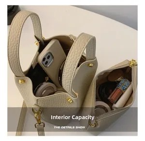 Detail of cream bucket bag interior capacity showing phone and makeup accessories