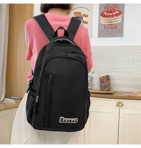 Detail of black large capacity backpack with RKDBAG patch and multiple zip pockets
