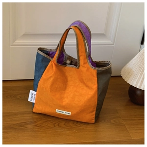 Close-up of color block tote bag with brand label and durable canvas fabric texture