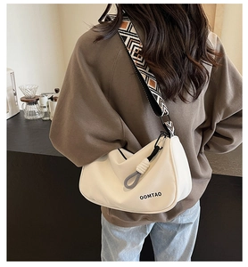 Detail of cream half-moon crossbody bag with ethnic geometric woven shoulder strap