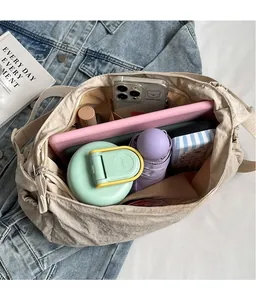 Spacious interior of beige nylon tote bag showing water bottle, umbrella and tablet