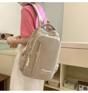 Detail of a beige waterproof nylon backpack with RKDBAG logo and functional side pockets