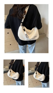 Detail of cream crescent crossbody bag with ethnic woven strap and logo text