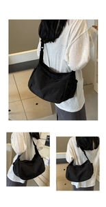 Detail of a black nylon crescent crossbody bag with adjustable wide shoulder strap