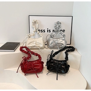 Detail of four colorful pleated bow handbags in cream, silver, burgundy, and black