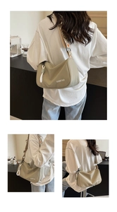 Detail of the crescent canvas bag featuring geometric wide strap and OOMTAO logo branding