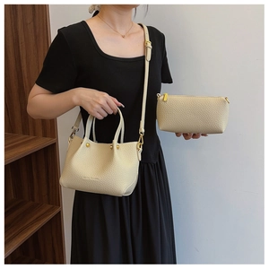 Detail of off-white lychee grain leather handbag set with adjustable strap and gold hardware