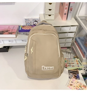 Detail view of khaki student backpack with RKDBAG label and rope zipper pulls