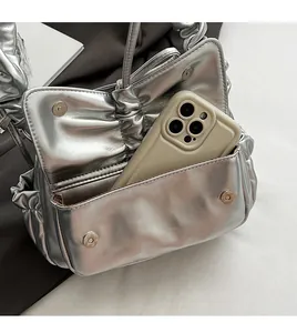 Detail of silver pleated bag showing a front pocket fitting a large smartphone