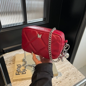 Quilted red shoulder bag with silver butterfly detail and chunky chain strap