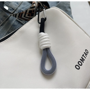 Macro shot of canvas tote texture with woven strap and decorative knotted charm details