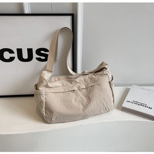 Detail of off-white nylon crossbody bag with functional double front zipper pockets