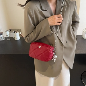Elegant red leather shoulder bag with silver butterfly charm and chain strap detail