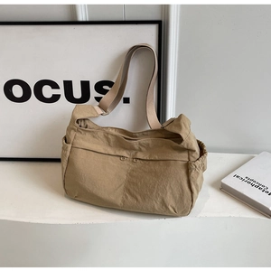 Detail view of khaki nylon functional shoulder bag with multi-pocket storage and wide strap