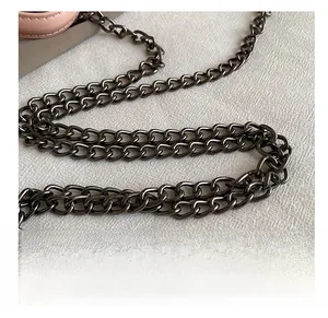 Detail view of gunmetal gray metal chain strap on pink leather handbag with links