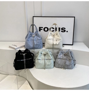 Detail view of five assorted bucket bags with ripple patterns and decorative pearl tassels