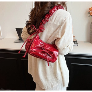 Détail du sac à bandoulière en PU rouge avec nœud décoratif et bandoulière style chouchou