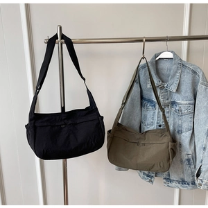 Detail of minimalist nylon crescent bags in black and olive green with wide shoulder straps