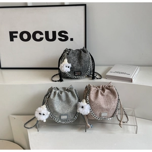 Detailed view of drawstring bucket bags in grey and pink with plush sheep charms